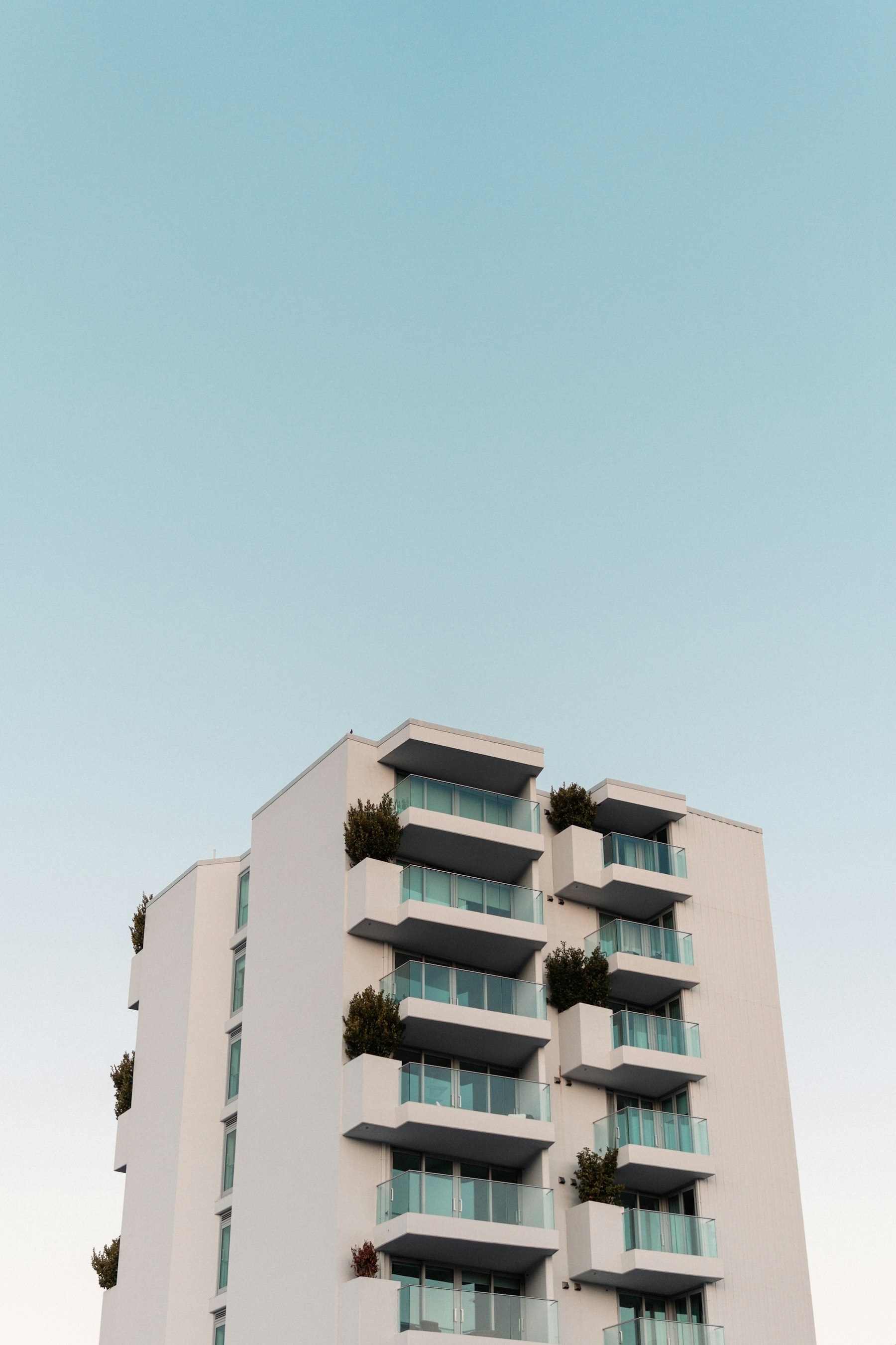 Edificio de departamentos moderno con balcones y vegetación